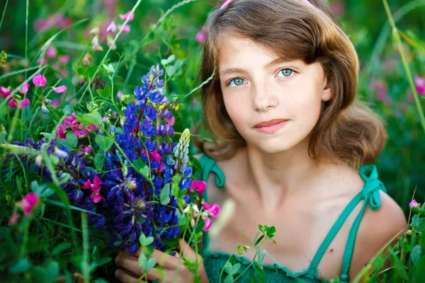 Petite fille dans le champ avec des fleurs — Photo