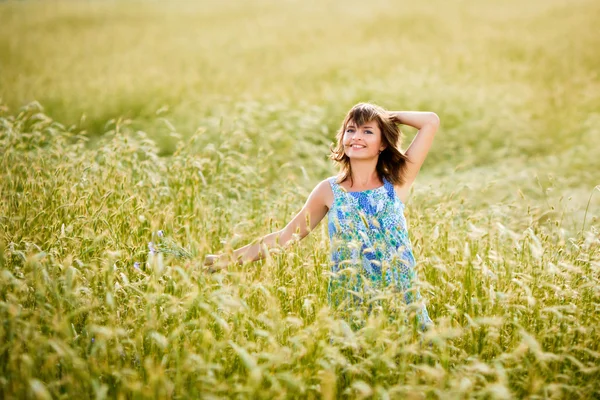 Hermosa chica sonriendo en un campo de trigo — Foto de Stock