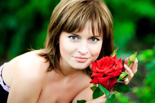 Bela mulher no jardim com rosas — Fotografia de Stock