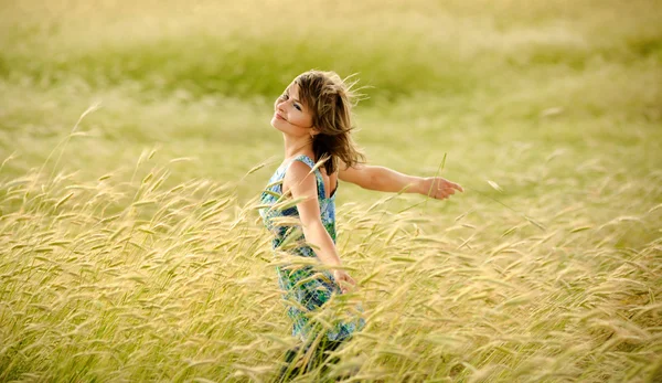 Mooi meisje glimlachen op een gebied van tarwe — Stockfoto