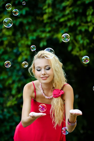 Hermosa chica rubia jugando con burbujas de jabón —  Fotos de Stock