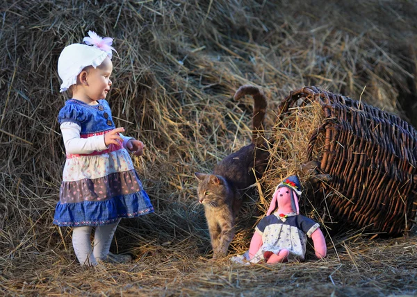 stock image Little girl and cat in the hayloft