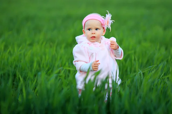 Kleines Mädchen posiert im grünen Gras — Stockfoto
