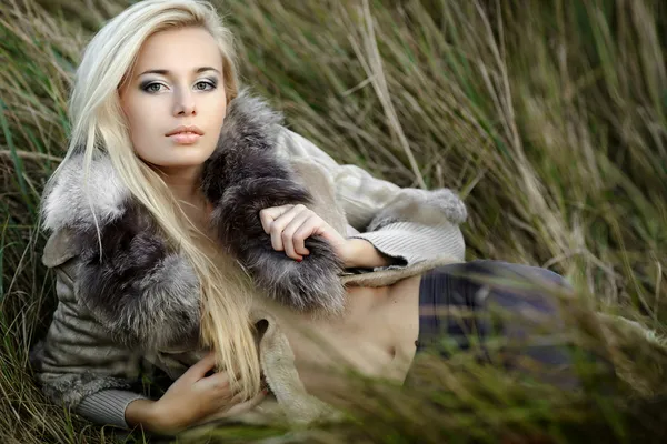 Chica en un abrigo de piel en el fondo de otoño —  Fotos de Stock