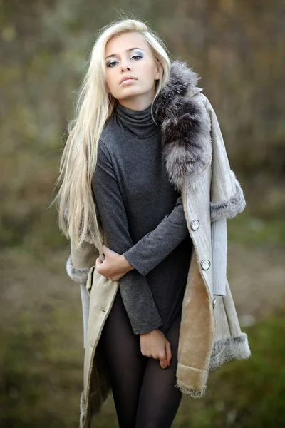 Κορίτσι σε ένα γούνινο παλτό στο παρασκήνιο φθινόπωρο — Φωτογραφία Αρχείου