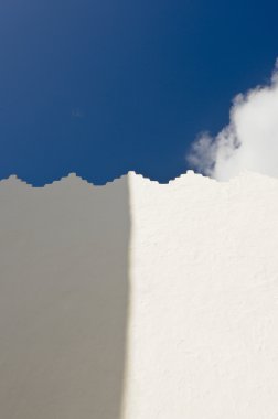 White wall with shadow and blue sky