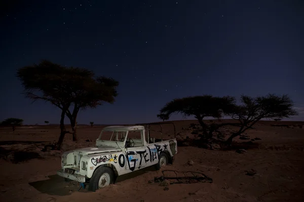 stock image Broken stranded off-road vehicle, middle of the desert, by nigh