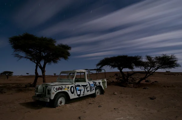 stock image Broken stranded off-road vehicle, middle of the desert, by nigh