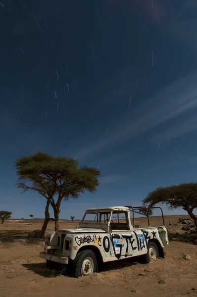 stock image Broken stranded off-road vehicle, middle of the desert, by nigh