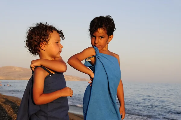 Two little girls posing dressed up in towels at seaside — Stok fotoğraf