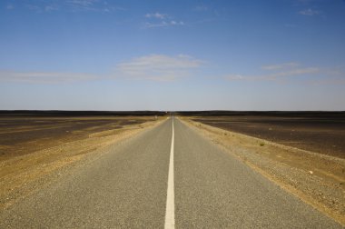 Empty black desert highway heading towards nowhere