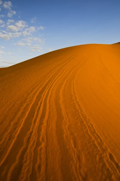 Γραμμές σε πορτοκαλί αμμόλοφο έρημο με το γαλάζιο του ουρανού — Φωτογραφία Αρχείου