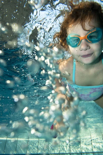 Menina pequena feliz nadando debaixo d 'água — Fotografia de Stock