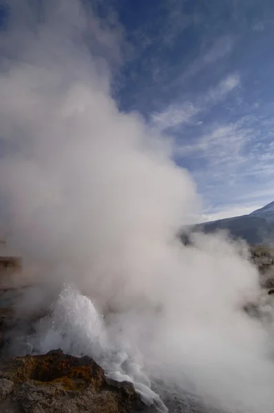 Erupting steamy geyser in geothermal field at sunrise — Stock Photo, Image
