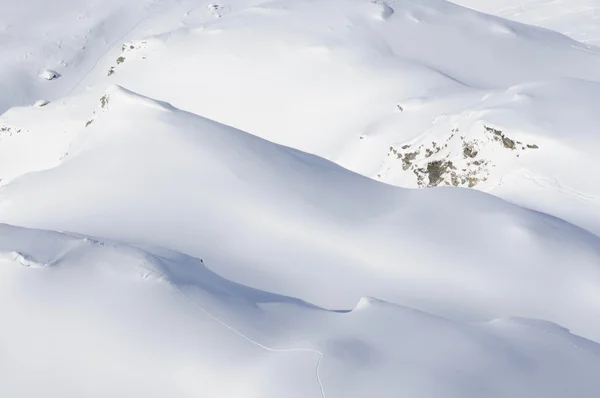 Vista aérea de montanhas cobertas de neve com trilhas únicas — Fotografia de Stock