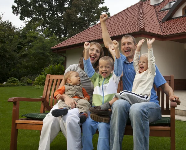Šťastná rodina na lavičce — Stock fotografie