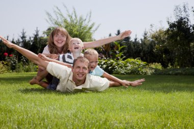 Happy Family playing an airplane in the garden clipart