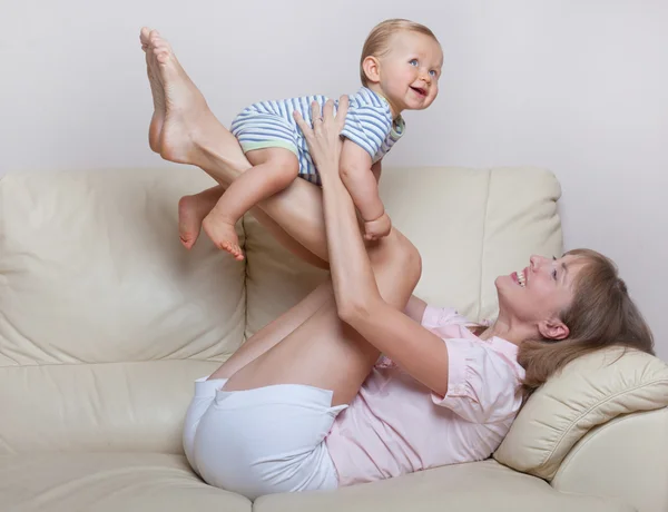 Niño y madre jugando en el sofá — Foto de Stock