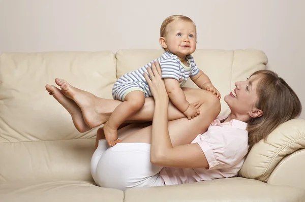 Criança e mãe brincando no sofá — Fotografia de Stock