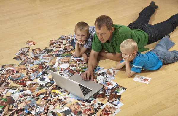 Familjen tittar på laptop på golvet Stockfoto