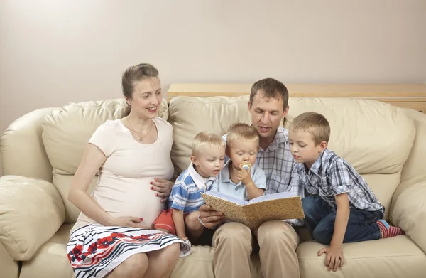 Familjen sitter i soffan och tittar på bilder — Stockfoto
