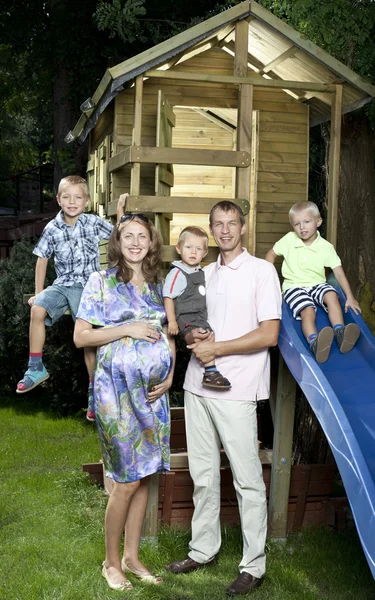 Familjen framför barn hus — Stockfoto