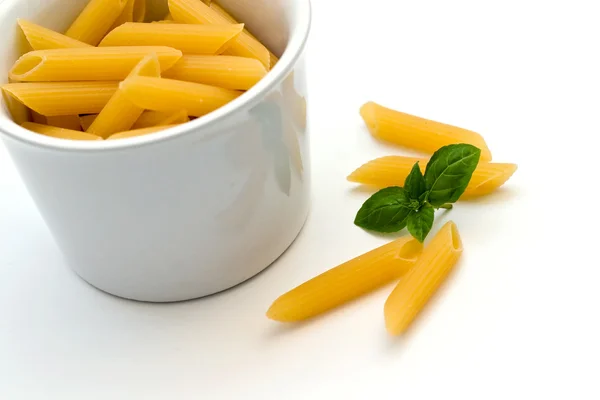 Uncooked pasta selection with basil decoration in a bowl — Stock Photo, Image
