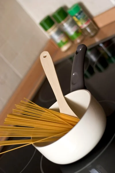 Esparguete não cozido em uma panela em um fogão — Fotografia de Stock