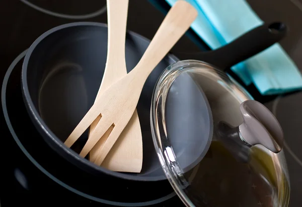 Сковородка с кухонной утварью на плите — стоковое фото