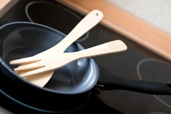 Frying pan with kitchen utensils on a stove — Stock Photo, Image