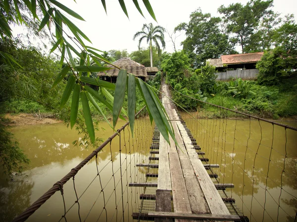 Ponte de suspensão de madeira cênica da aldeia local Fotos De Bancos De Imagens