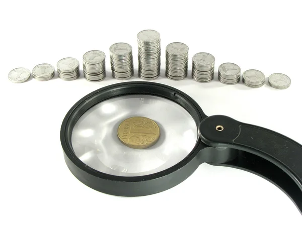 Mynt och ett förstoringsglas — Stockfoto