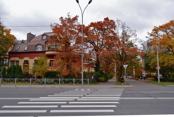 Stock image A beautiful red two-story house in a background of red autumn tr