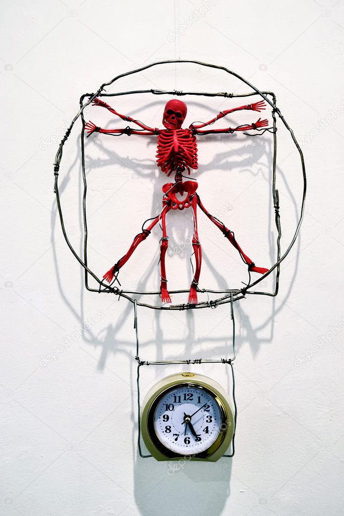 Red toy skeleton, which hangs over a mechanical alarm clock - a