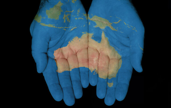 Map painted on hands showing concept of having Australia in our hands