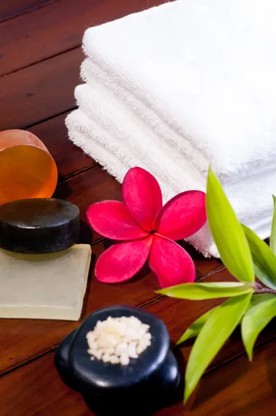 Spa koncept s zen stone, koupelová sůl, mýdlo a červený květ — Stock fotografie