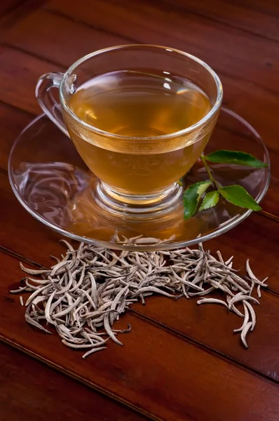 Srebrne wskazówki herbaty na drewnianym stołem — Zdjęcie stockowe