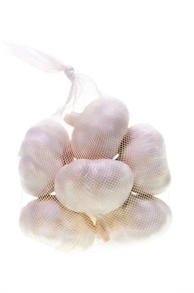 Bulbs of garlic in a bag vertical — Stock Photo, Image