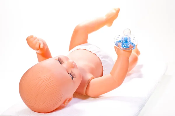 stock image Old baby doll lying on a towel