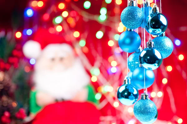 Natal azul pendurado bugigangas com o Papai Noel no fundo — Fotografia de Stock