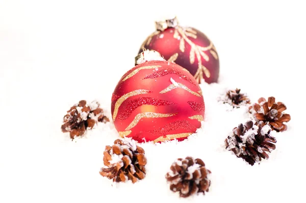 Kırmızı baubles ve pinecones karda — Stok fotoğraf
