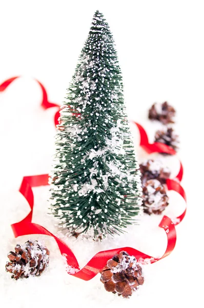 Mini-Weihnachtsbaum mit Tannenzapfen auf Schnee — Stockfoto