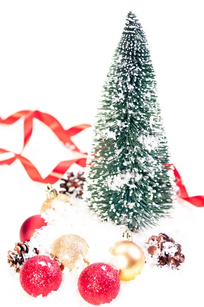 Mini julgran med tallkotte och grannlåt på snö — Stockfoto