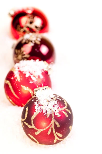 Quattro palline rosse di Natale sulla neve — Foto Stock