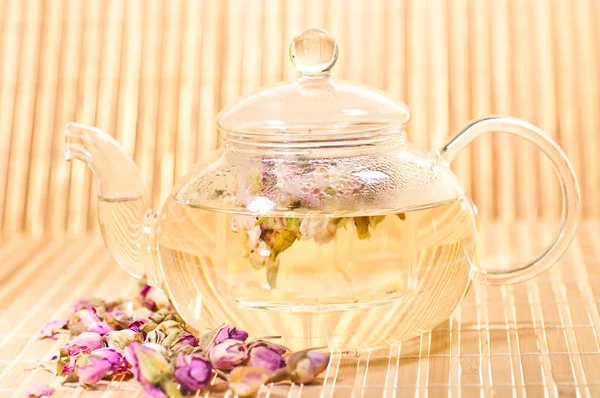 Pink rose tea in a glass teapot — Stock Photo, Image
