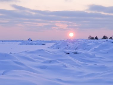 Sunset and snow on the coast of the Gulf of Finland. clipart