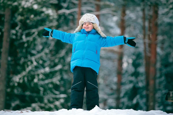 Retrato de um menino brincando ao ar livre em uma floresta de inverno — Fotografia de Stock
