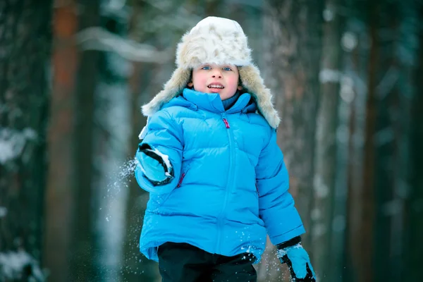 Porträt eines kleinen Jungen, der draußen im Winterwald spielt — Stockfoto