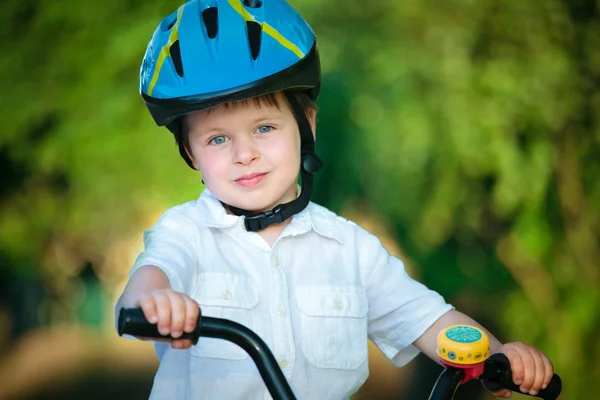 Happy boy on a bicycle in a summer park. — Stock Photo, Image