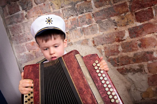 Portréja egy aranyos fiú, játszott a harmonika — Stock Fotó